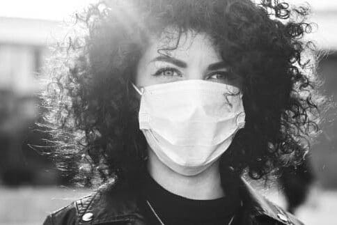 Fair Lakes Family Cosmetic Dentistry Woman In Mask woman with short curly hair wearing mask covid policy