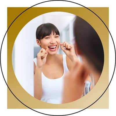 woman flossing in mirror